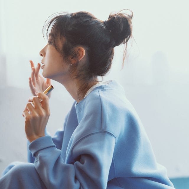 person sitting on the floor applying lipstick