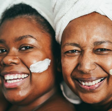 african mother and daughter doing beauty treatment at home using skin mask focus on senior woman eyes
