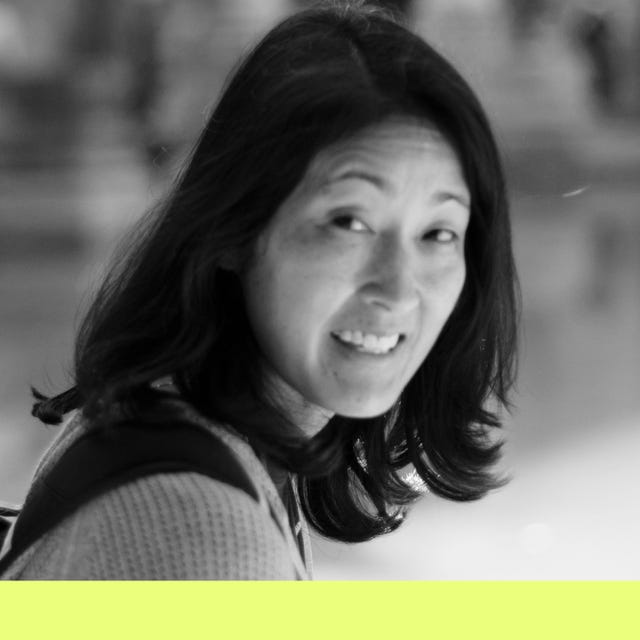 a person with long hair and a backpack in a blurred background