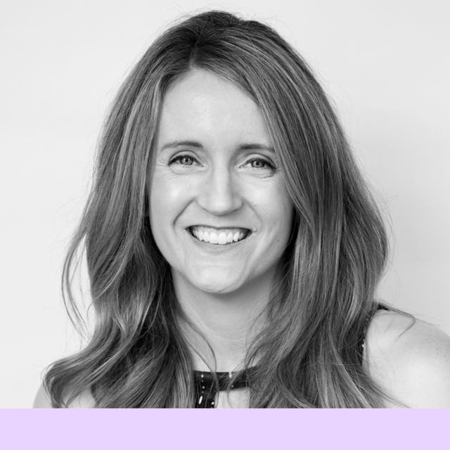 a person with long hair wearing a black top against a plain background