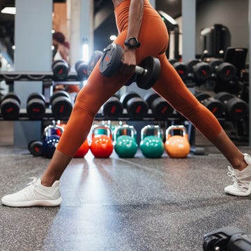 anonymous sportswoman using dumbbells for her workout session at the gym