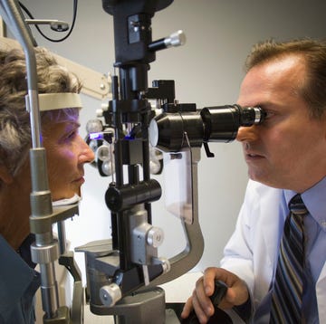 eye doctor checking woman's eyes