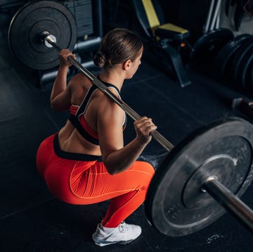 women doing barbell back squat
