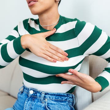 young african american woman palpating her breast by herself that she concern about breast cancer healthcare and breast cancer concept
