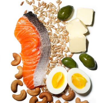 keto friendly foods on a white background: salmon, cashews, hard boiled eggs, olives, cheese, and seeds