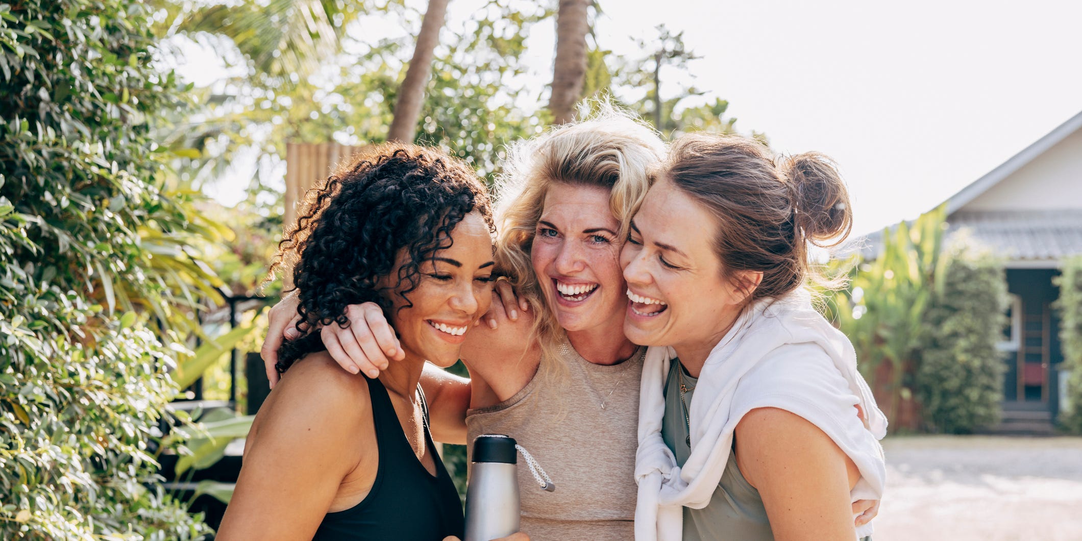 three women embracing in an outdoor setting