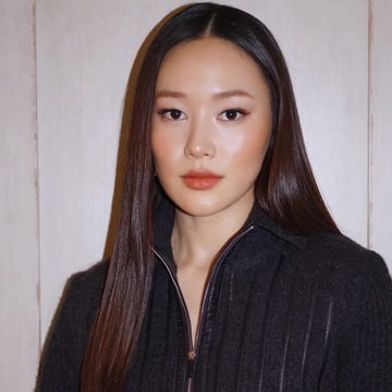 portrait of a person with long straight hair wearing a zippered ribbed black top