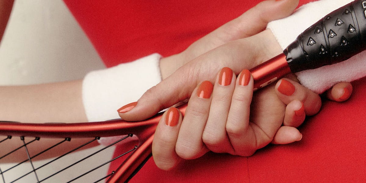 hands holding a tennis racket featuring manicured nails