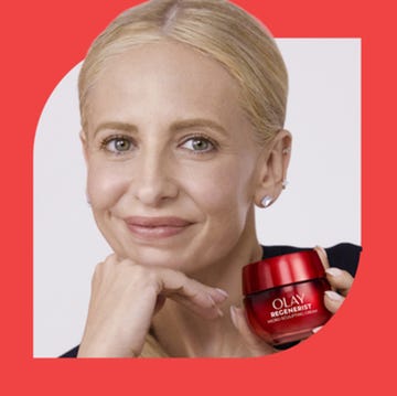 woman holding a skincare product against a red background