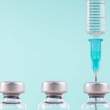 vials of vaccine and a syringe on a blue background