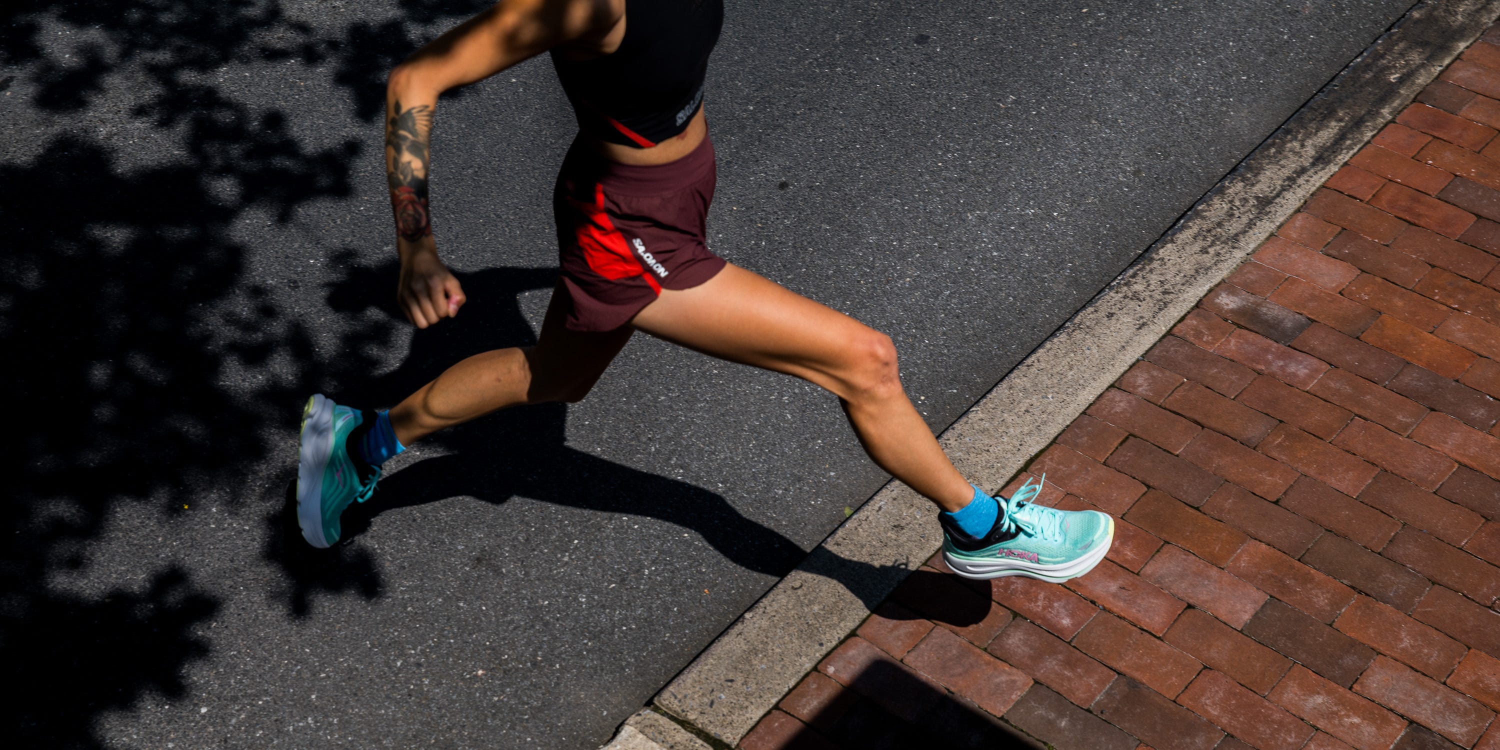 a woman running in a pair of hoka running shoes