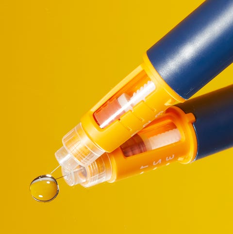 pen with a transparent tip and a water droplet on a reflective surface
