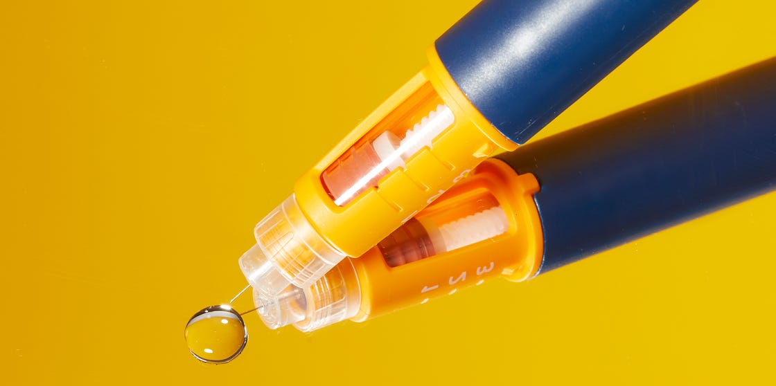 pen with a transparent tip and a water droplet on a reflective surface