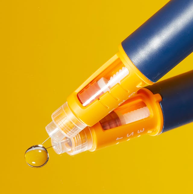 pen with a transparent tip and a water droplet on a reflective surface
