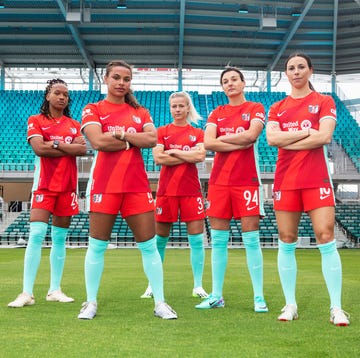 a group of women in red uniforms on a field
