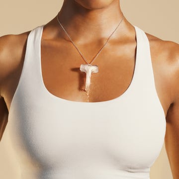 woman wearing a white crop top and a distinctive necklace