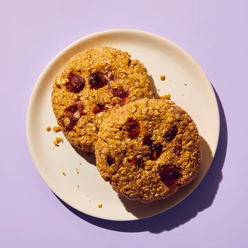 two oatmeal cookies on a plate against a purple background
