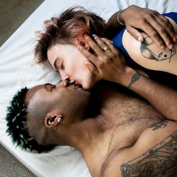 a young lgbt couple kissing and hugging in bed
