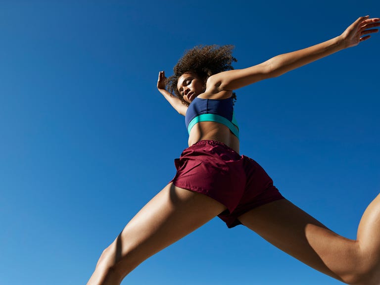 young woman exercising against clear sky