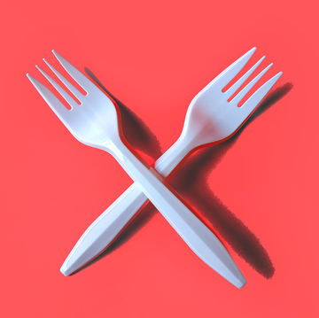 two white plastic forks on red background