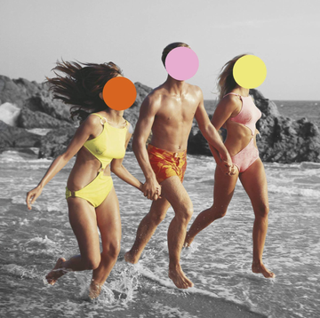 group of three people running through the ocean waves